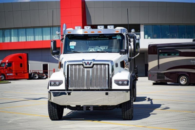 Western Star 47X rolloff truck front view in dealership lot showing chrome grille and large bumper.
