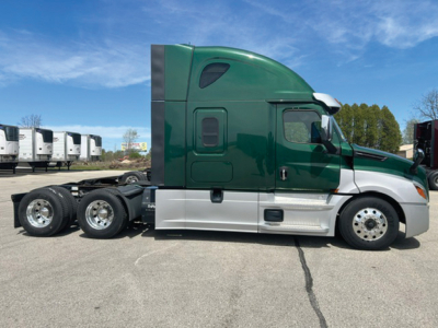 Truck side view showing Freightliner Cascadia 126 sleeper cab with green and silver paint, rear axles, and chrome wheels.