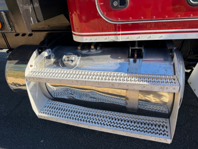 Peterbilt 335 fuel tank and chrome running board/step showing polished metal surfaces and perforated grip tread.