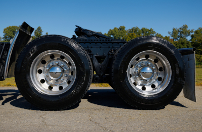 Kenworth W900L truck chassis dual rear axles wheel set showing polished rims and tires.