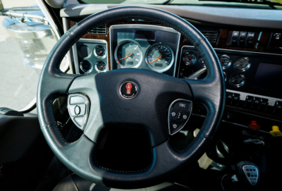 Kenworth W900L interior steering wheel and dashboard view showing gauges and controls.