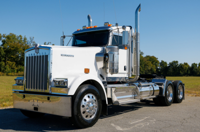 Kenworth W900L conventional sleeper tractor in white with chrome accents and dual rear axles, front grille and headlights visible.