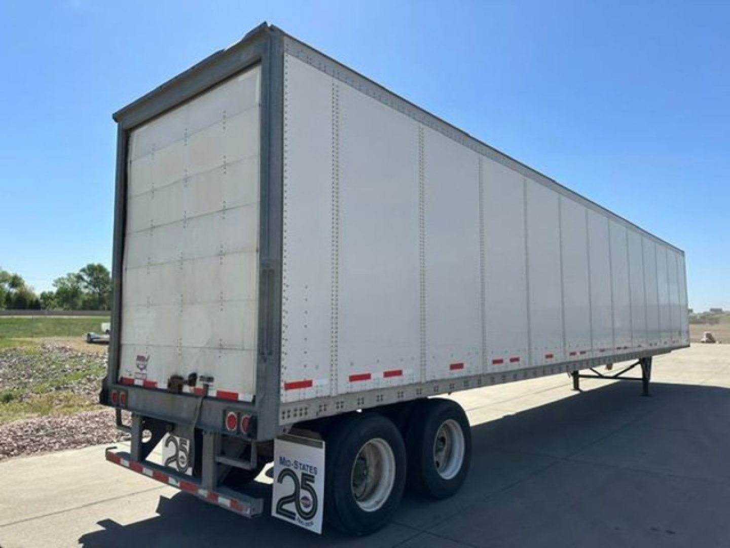  Trailer body showing box trailer with three axles and rear lights.