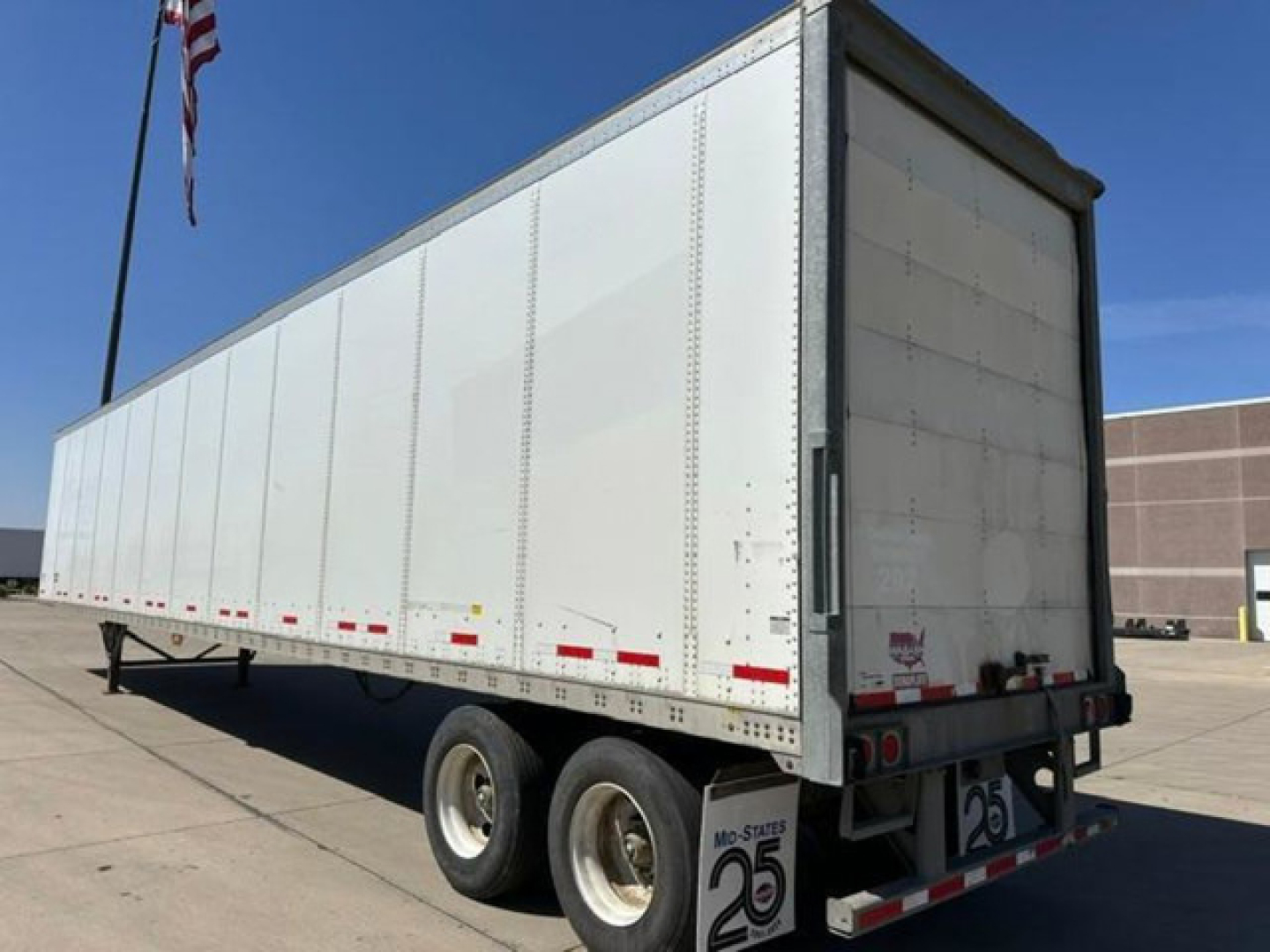 Heavy-duty white Wabash van trailer with dual rear axles, side reflectors, and rear doors; basic exterior viewed at an angle.