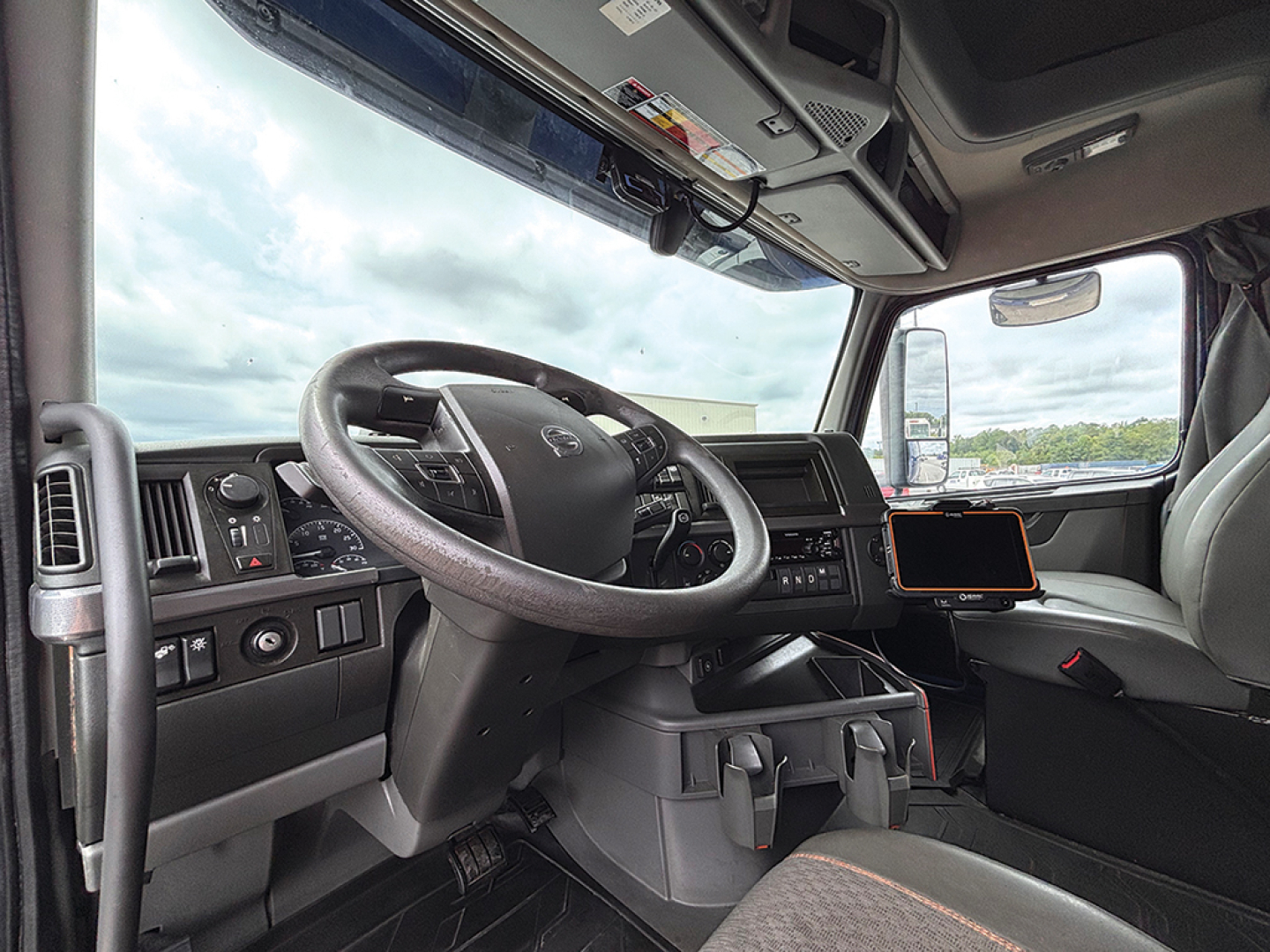 Volvo VNL 760 truck cab interior showing steering wheel, dashboard, and center console with mounted tablet.