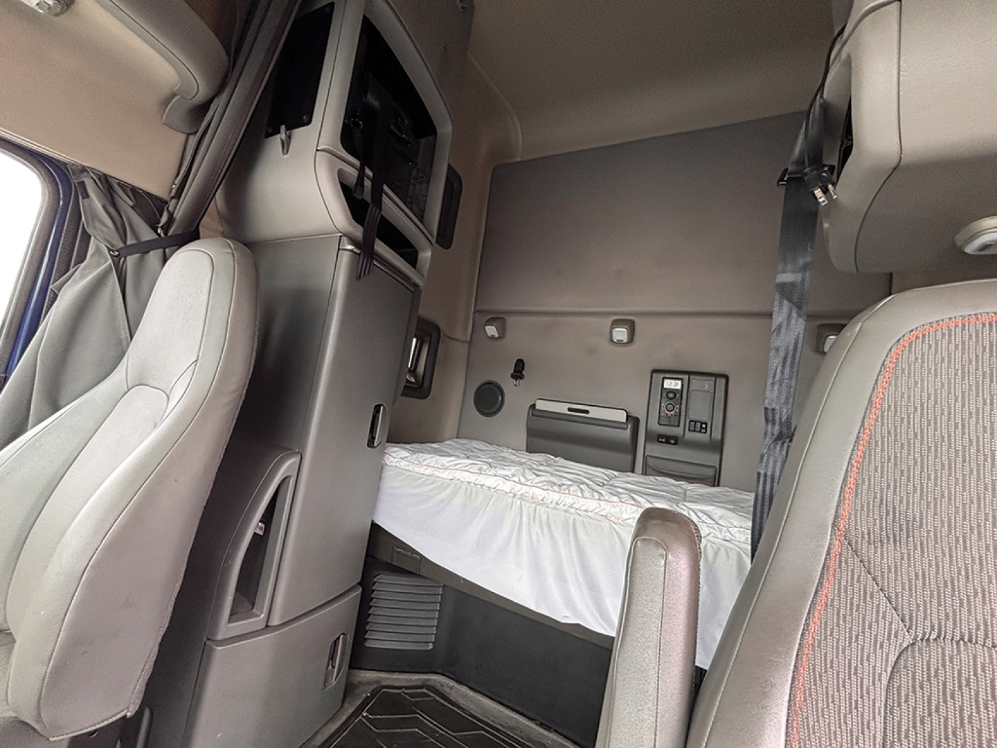 Interior cab of a 2022 Volvo VNL 760 sleeper showing bunk bed area and dashboard storage components.