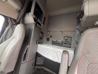 Interior cab of a 2022 Volvo VNL 760 sleeper showing bunk bed area and dashboard storage components.