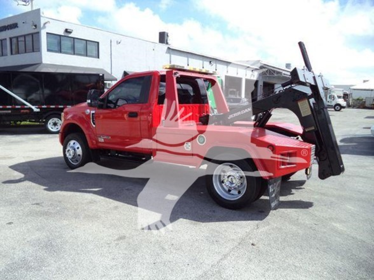 Truck mounted winch on a red 2017 Ford F-450 pickup with a large black winch bed in a dealership lot.