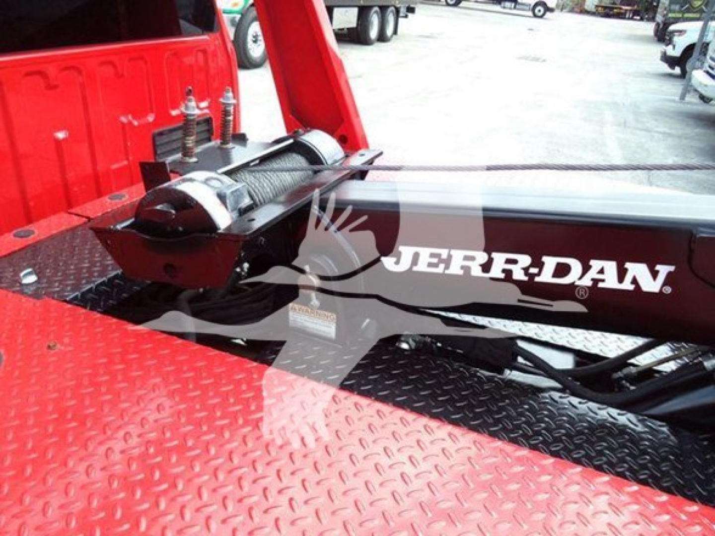 Ford F-450 winch truck bed showing JERR-DYNN winch assembly and hydraulic line with rugged diamond plate bed surface.