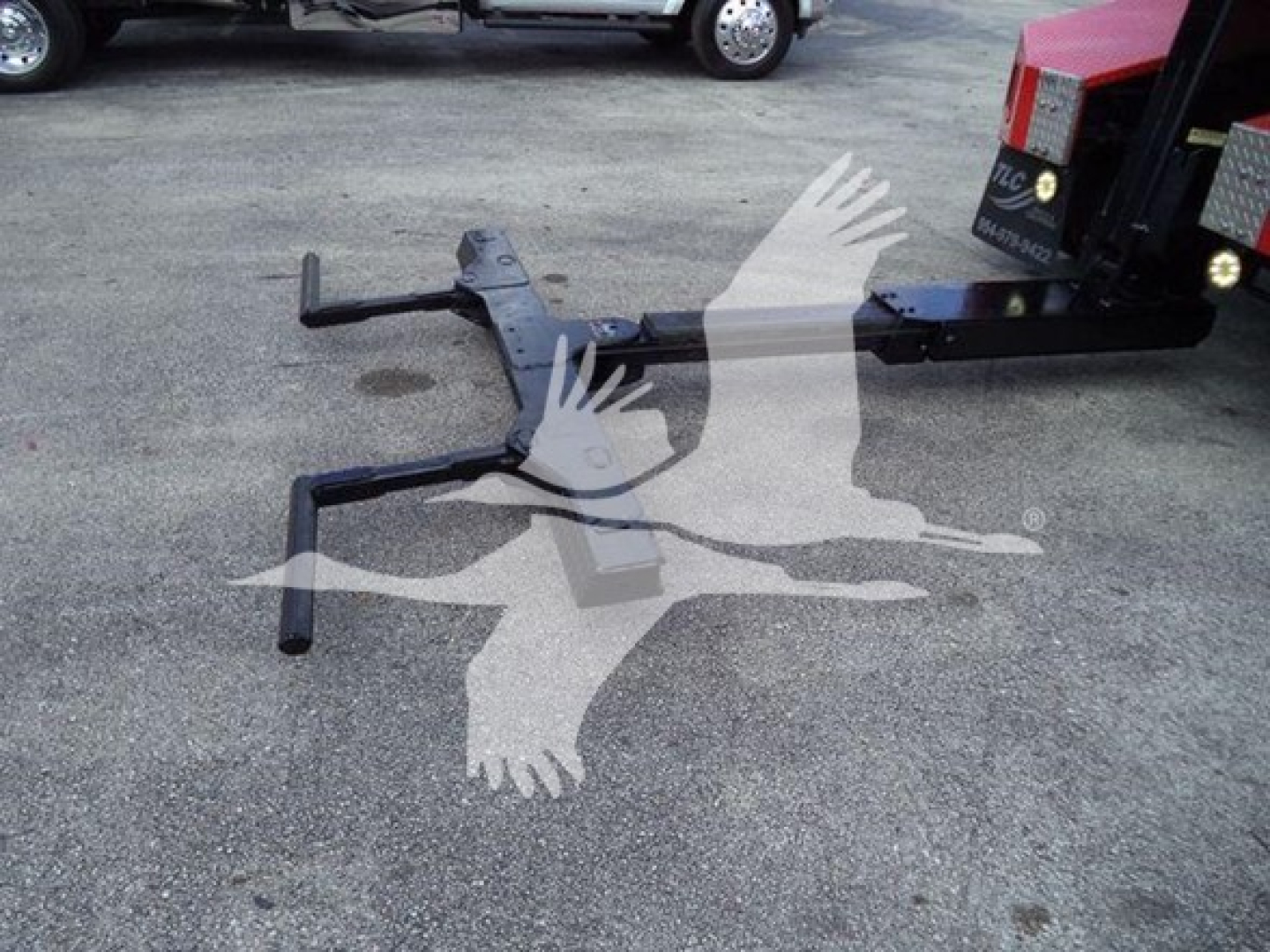 Ford F-450 winch-equipped truck hitch assembly with mounting bracket and outriggers visible on asphalt.