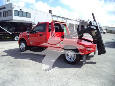 Truck mounted winch on a red 2017 Ford F-450 pickup with a large black winch bed in a dealership lot.