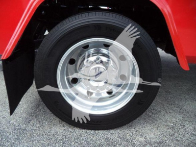 Ford F-450 wheel and tire with polished alloy wheel, red fender in background, no visible text except partial tire branding