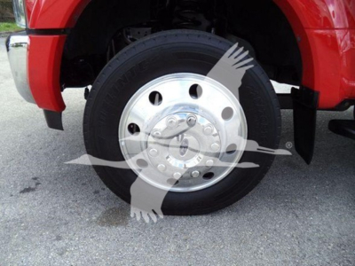 Ford F-450 wheel and tire in front fender view; chrome hub with multiple lug nuts; wheel well and red body panel visible; part of winch truck listing.