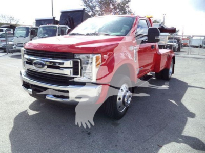 Ford F-450 pickup truck in red with winch equipment visible, front grille and wheels in view.