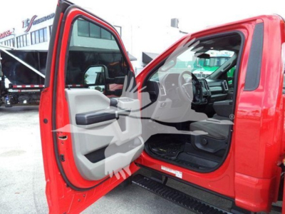 Ford F-450 cab interior with front doors open, showing dashboard and seat; side step and red exterior visible.