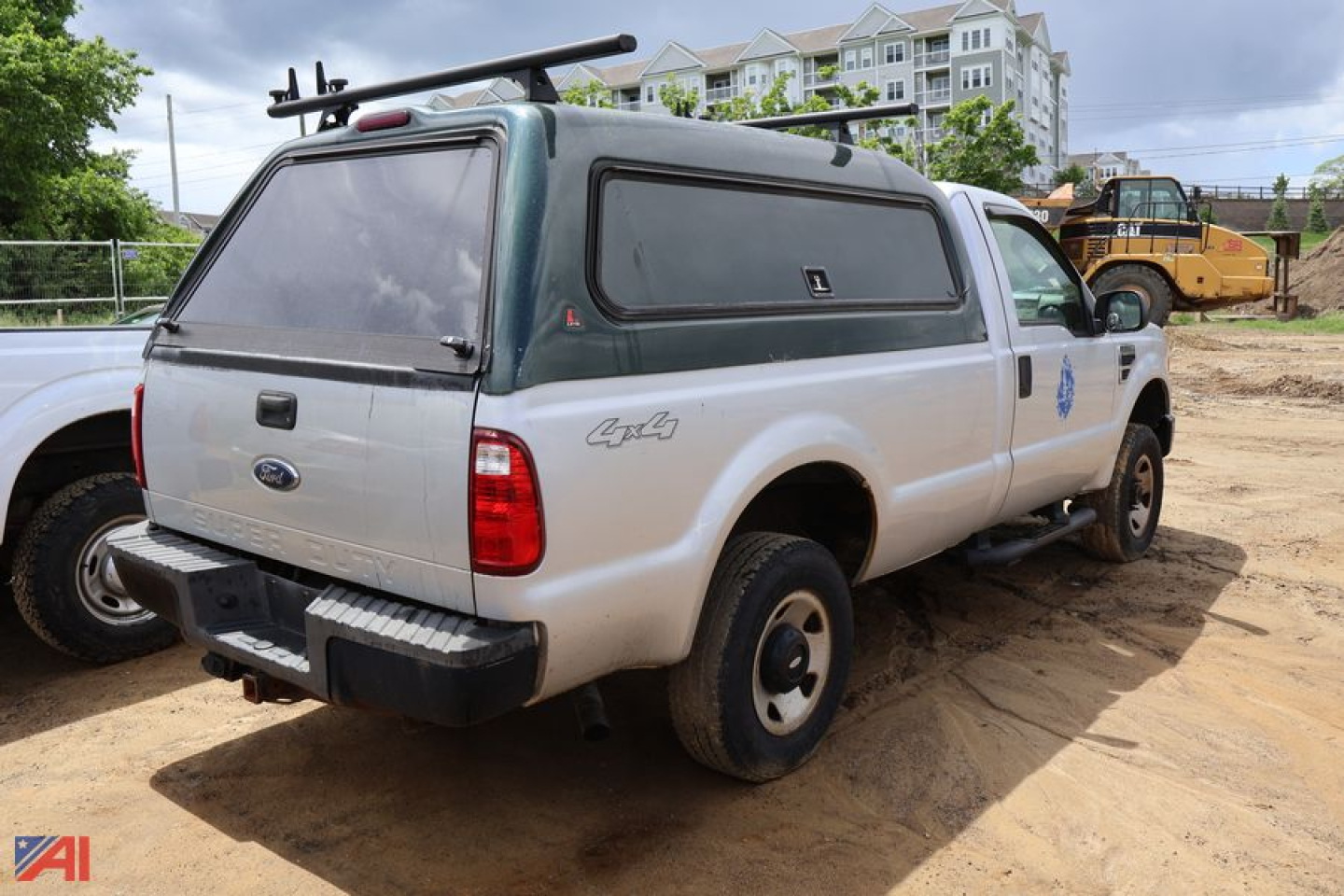 Ford F-250 Super Duty pickup with green camper shell and rear ladder rack, cargo area, rear view showing taillights and bumper