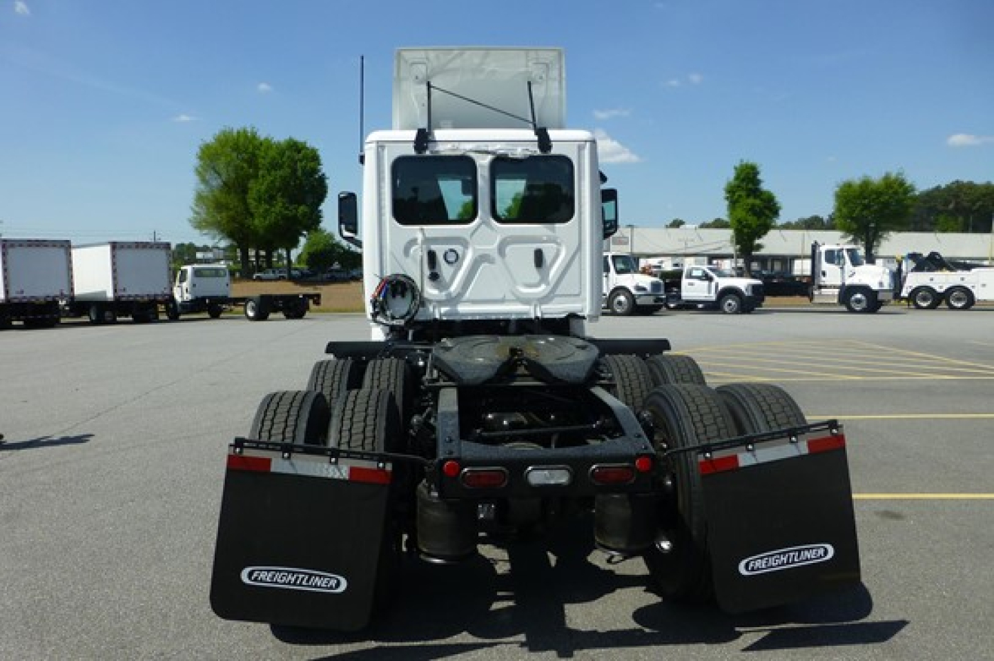 Freightliner Cascadia 126 day cab chassis rear view showing fifth-wheel, dual rear axles, mud flaps with Freightliner logos.