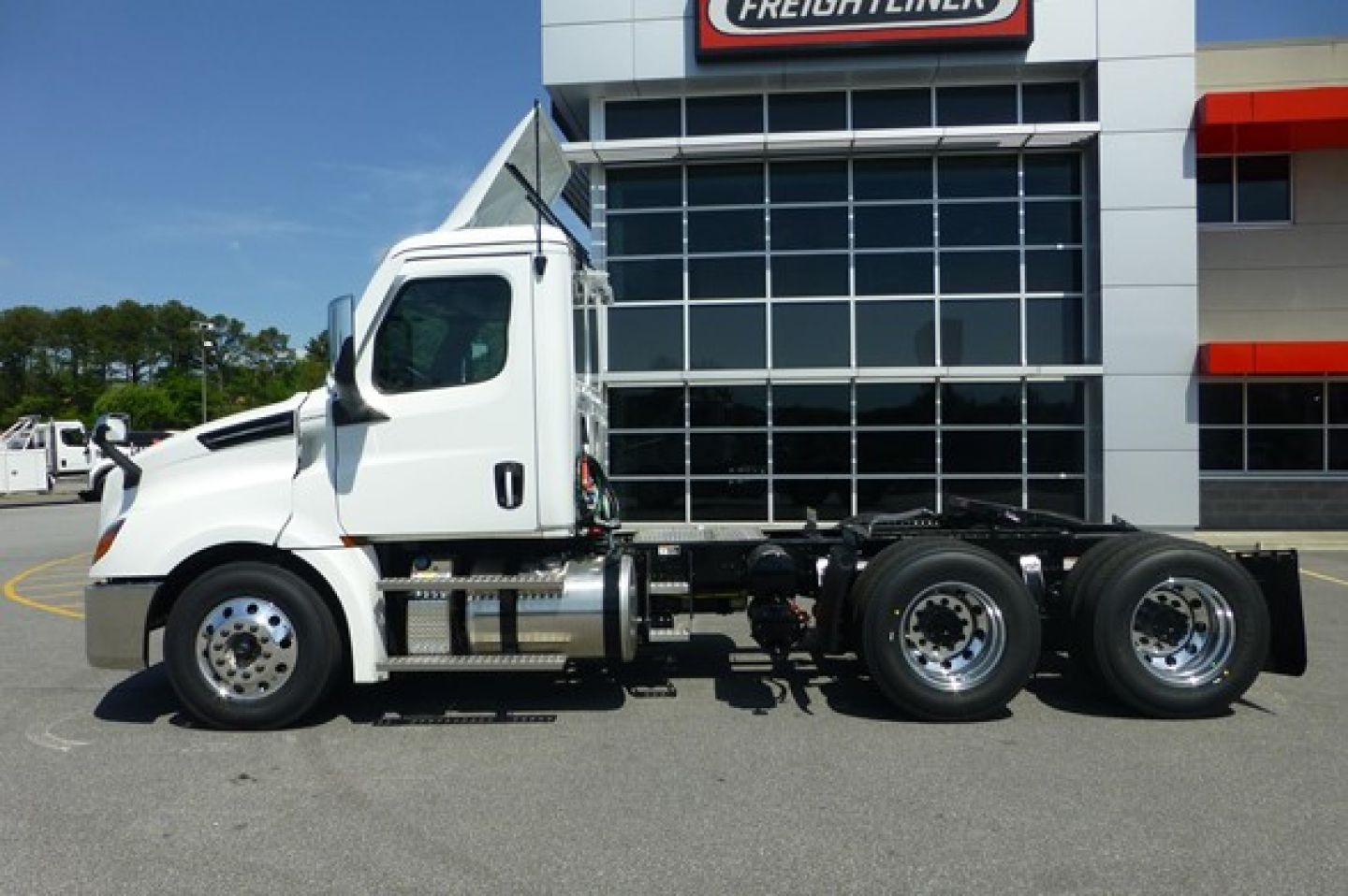 Freightliner Cascadia 126 day cab tractor truck side view showing cab, chassis, dual rear axles, and chrome fuel tanks