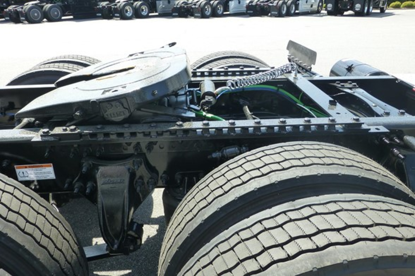 Truck chassis and rear section of a Freightliner Cascadia 126 tractor showing the fifth wheel and dual rear axles with tires.