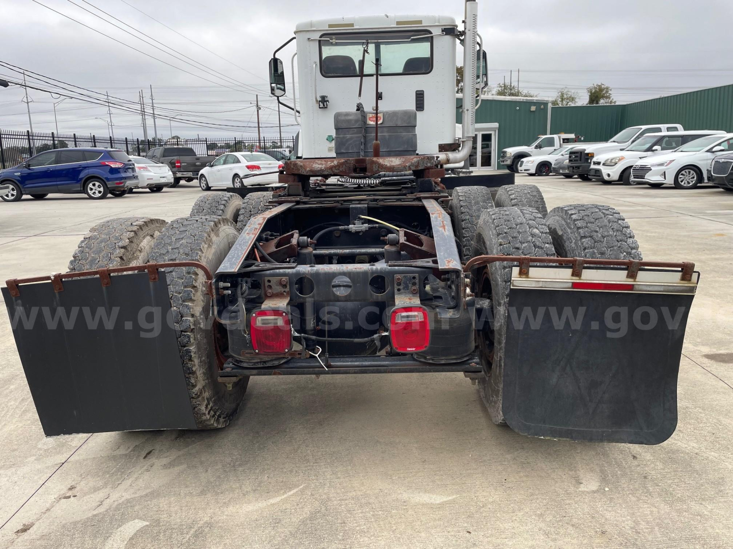 Rear view of a used Caterpillar CF7AA trucks chassis with dual rear axles, mud flaps, and brake/lighting assembly visible.