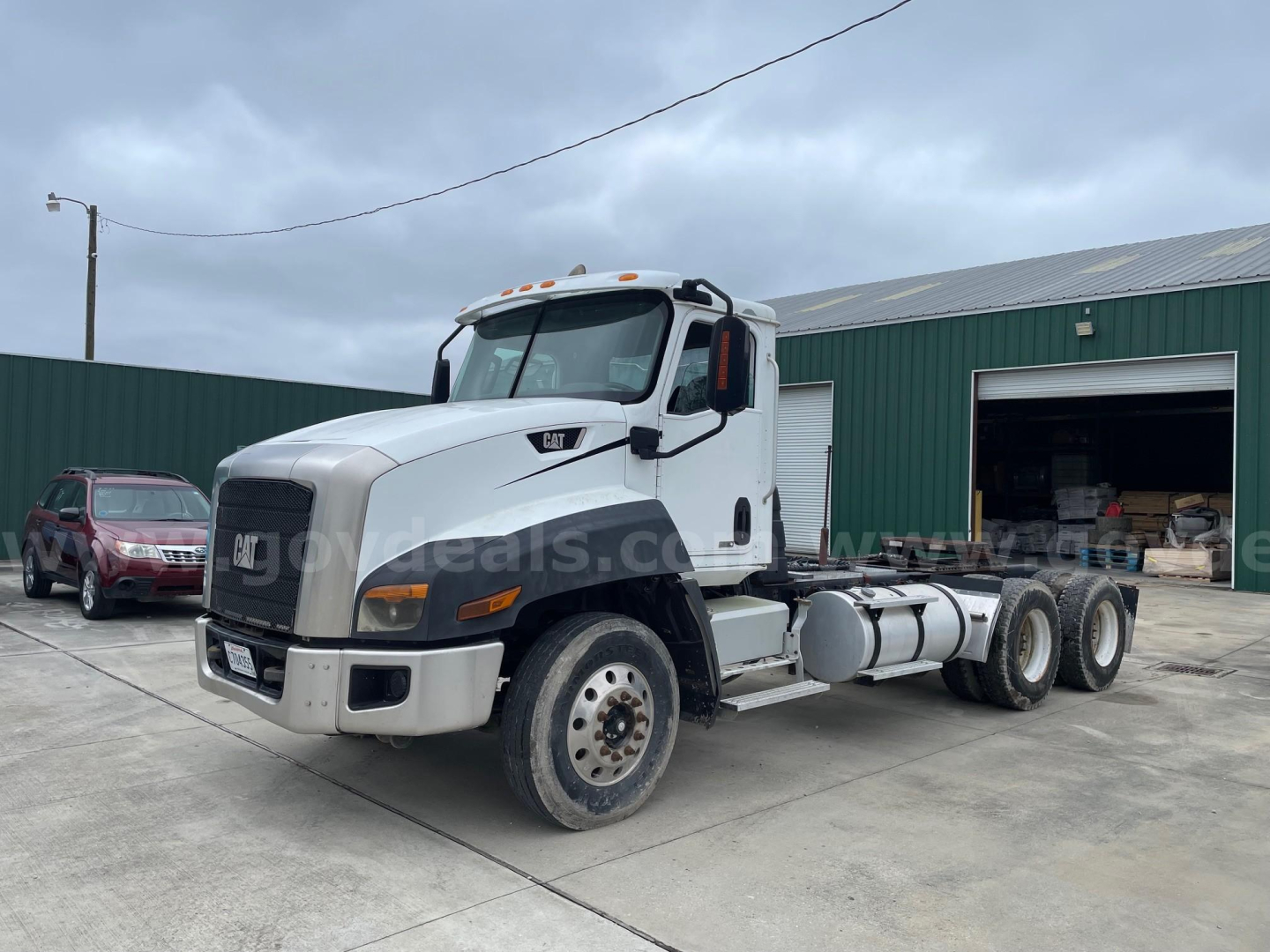 Caterpillar CF7AA truck in a yard showing a white semi tractor cab with dual rear axles and fuel tanks on the side.