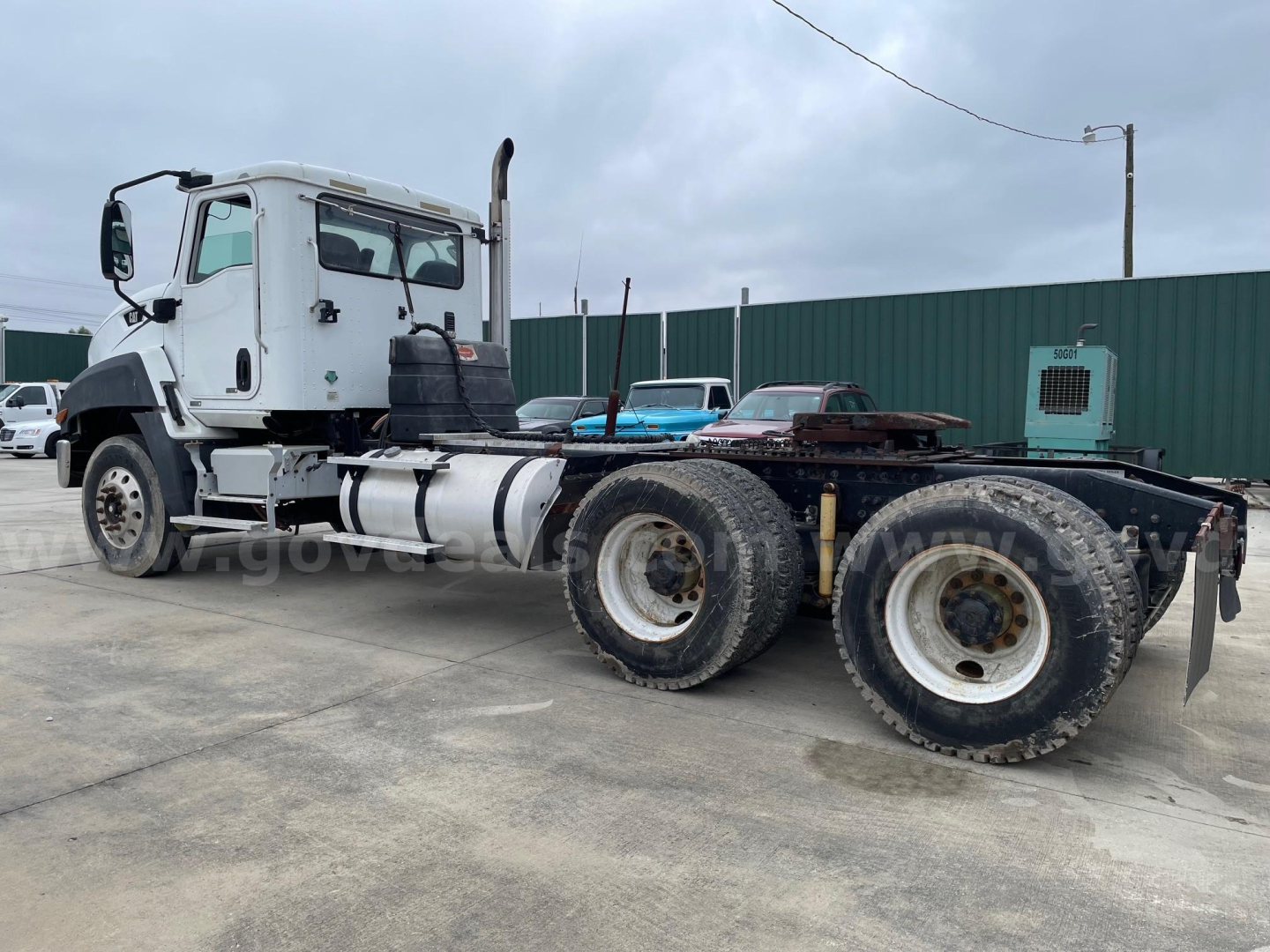 Tractor-trailer truck chassis with cab and dual rear axles; visible components include fuel tanks, exhaust stack, and fifth wheel mounting. No legible brand or model text visible.