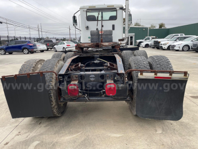 Rear view of a used Caterpillar CF7AA trucks chassis with dual rear axles, mud flaps, and brake/lighting assembly visible.