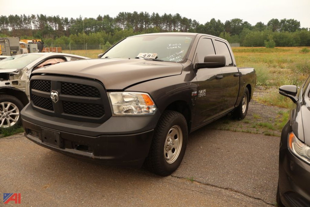 Ram 1500 pickup truck in black, front-left view, 2015 model year, 4x4, in a lot with other vehicles.