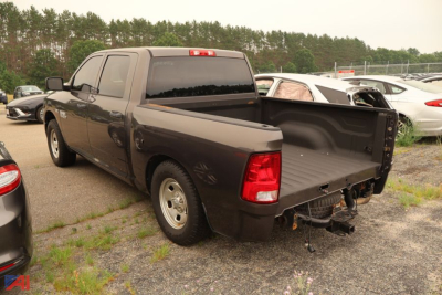 Ram 1500 pickup truck in a used condition, truck bed open with hitch and rearview showing tailgate area.