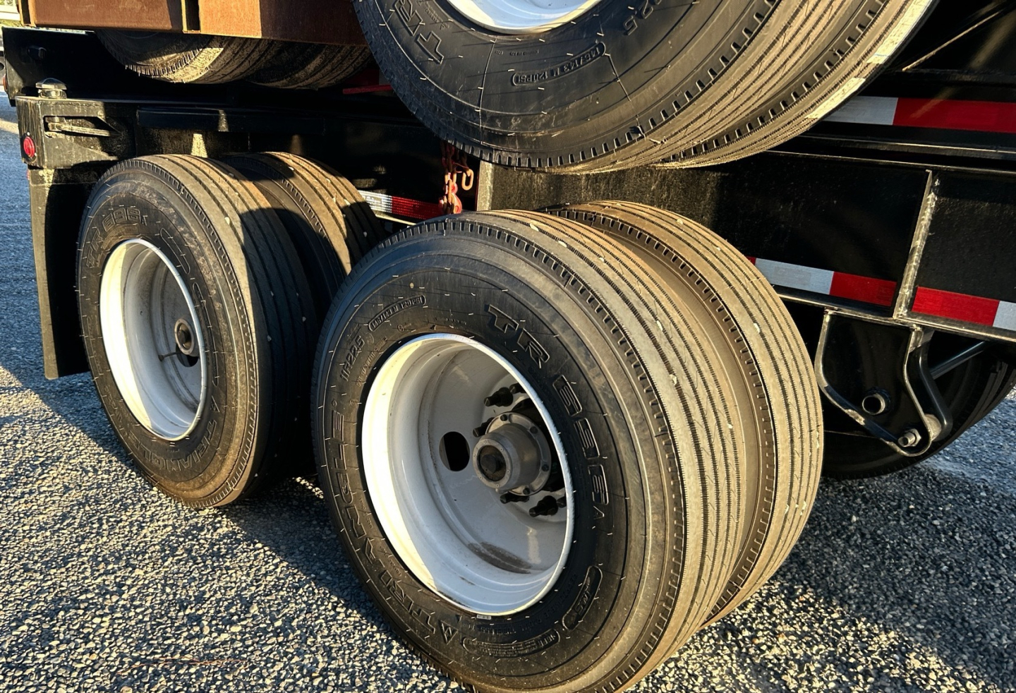 Trailer dual rear axles with white rims and black tires, visible undercarriage of a Gallegos 40' intermodal chassis.