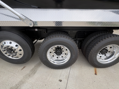 Triple rear axle section of a Volvo VHD truck showing dual rear tires and chrome rims with polished wheel hubs.