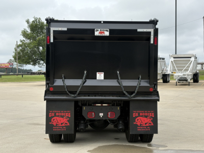 Volvo VHD84F300 dump truck rear view showing empty dump bed and mud flaps with red graphics.