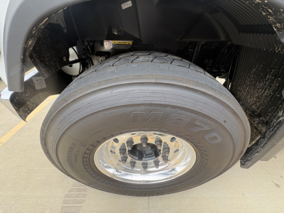 Volvo VHD84F300 front left wheel showing M700 tire and chrome hub, truck fender and suspension components visible.