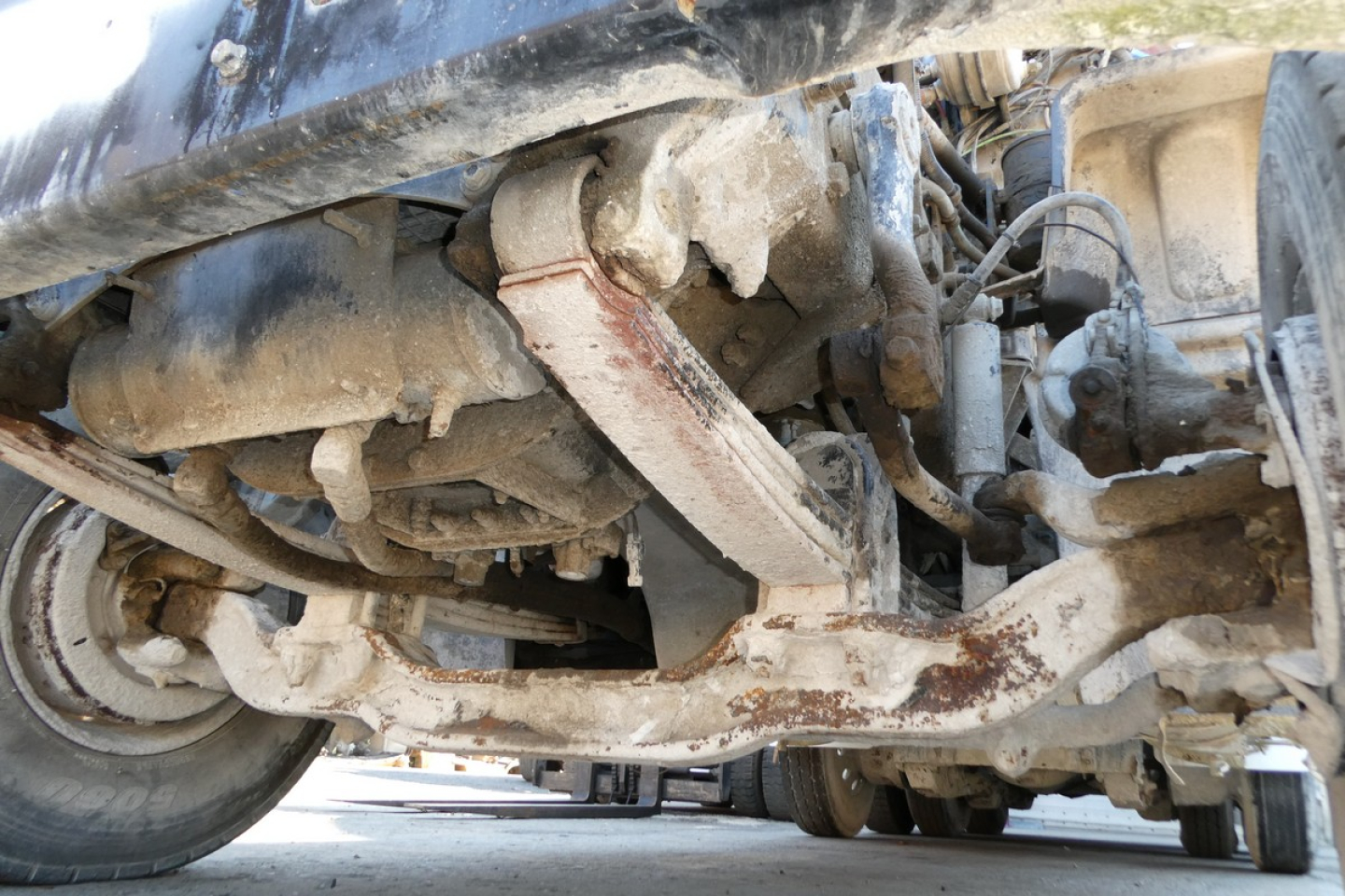 Undercarriage view of a 2007 Mack CTP713 mixer truck showing drivetrain and suspension components with rust-colored dirt.