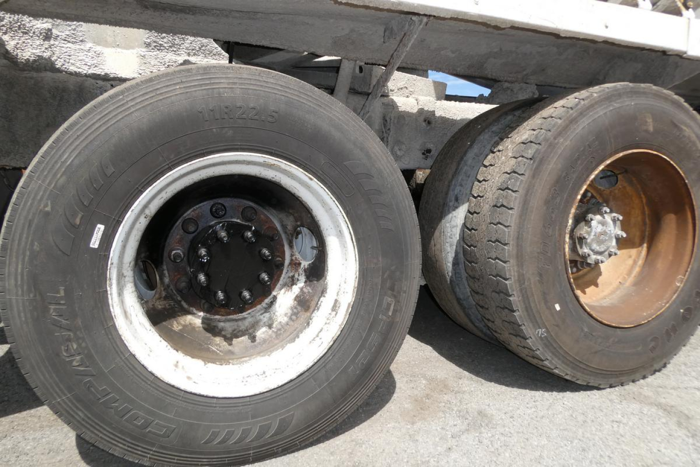 Wheel area of a 2007 Mack CTP713 mixer truck showing front dual wheels with worn tires and rims.
