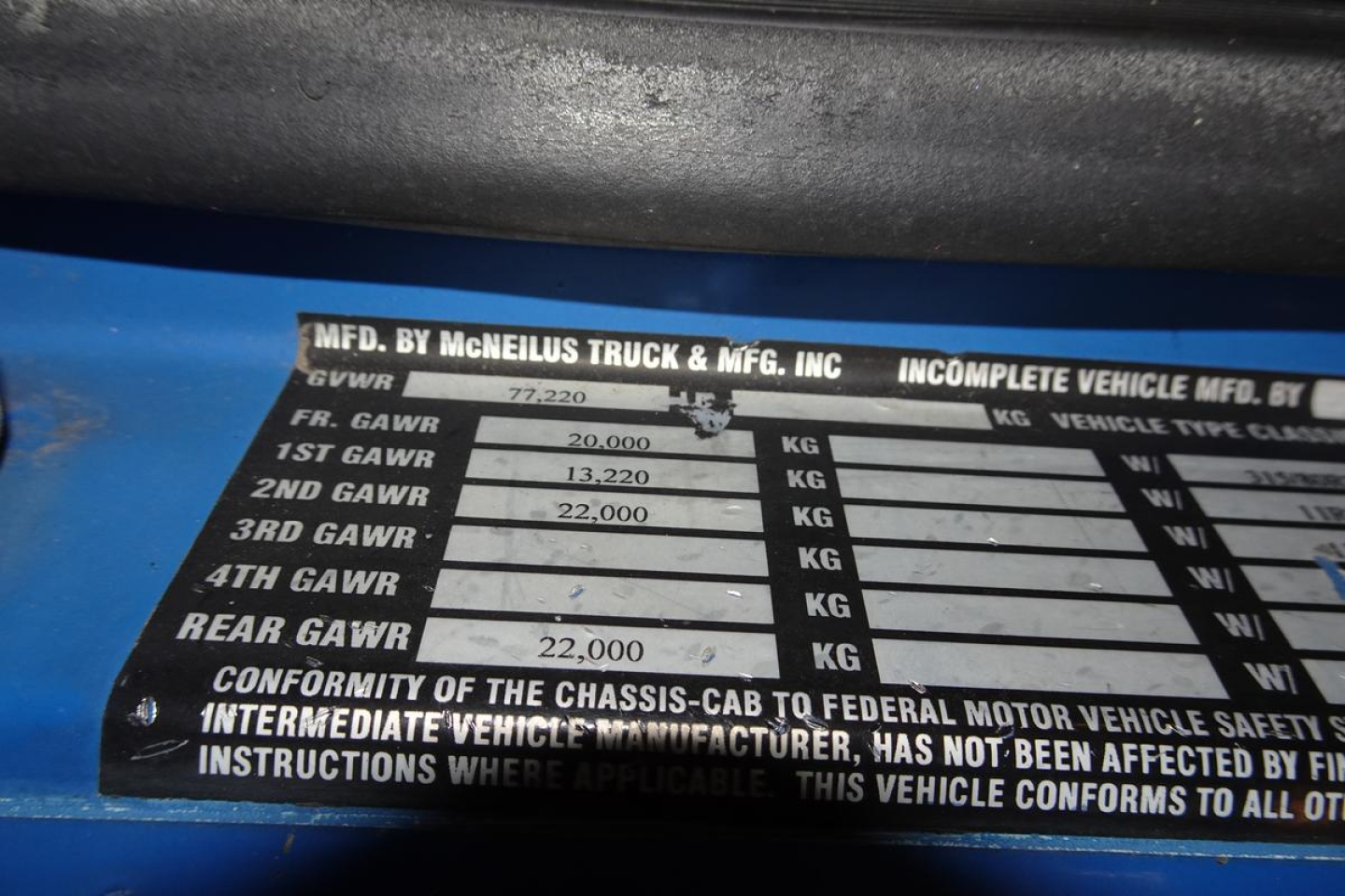 Mack chassis data plate showing GVWR and GAWR figures, with “MFD BY MCNEILUS TRUCK & MFG. INC.” and weights listed for front/rear axles.