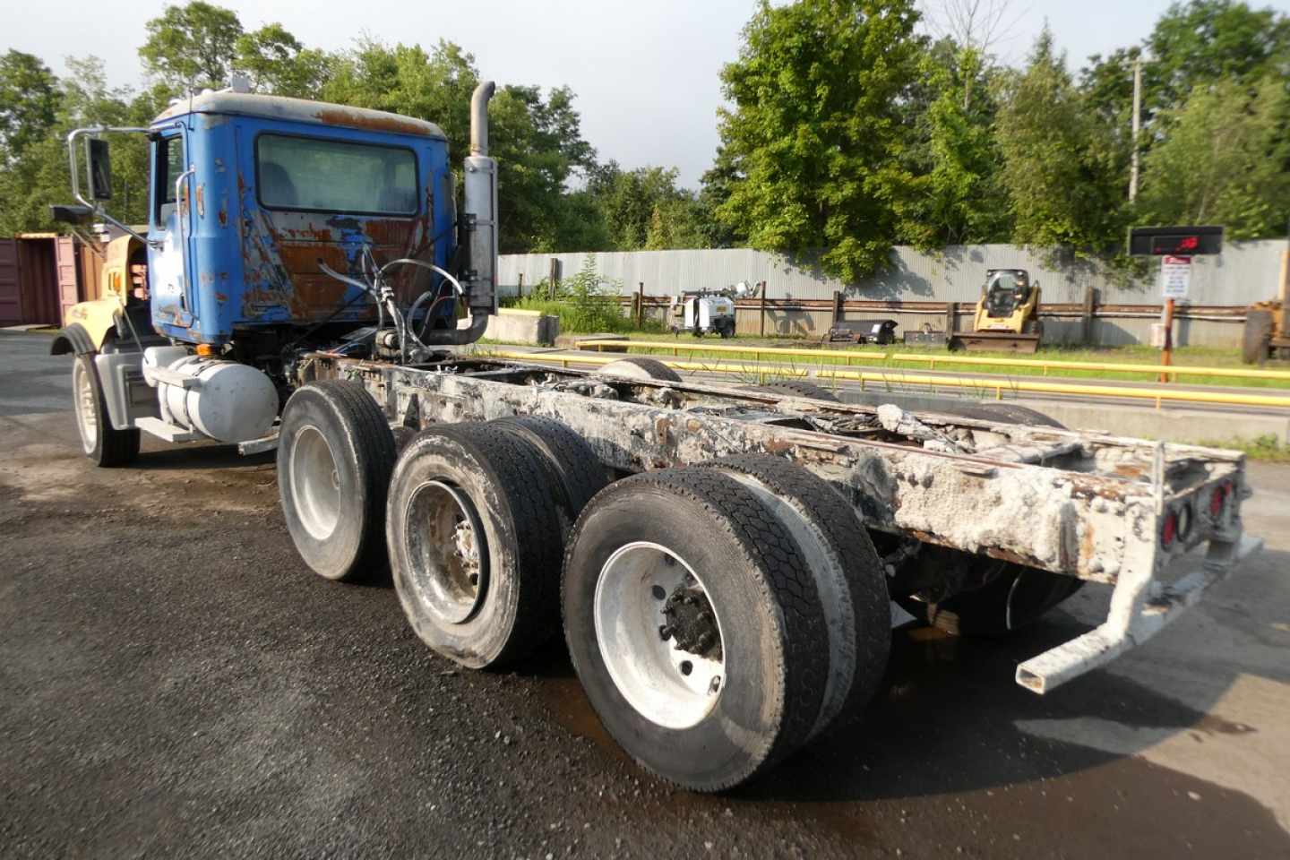 Mack CTP713 mixer truck chassis showing rear wheels and frame with weathered components.