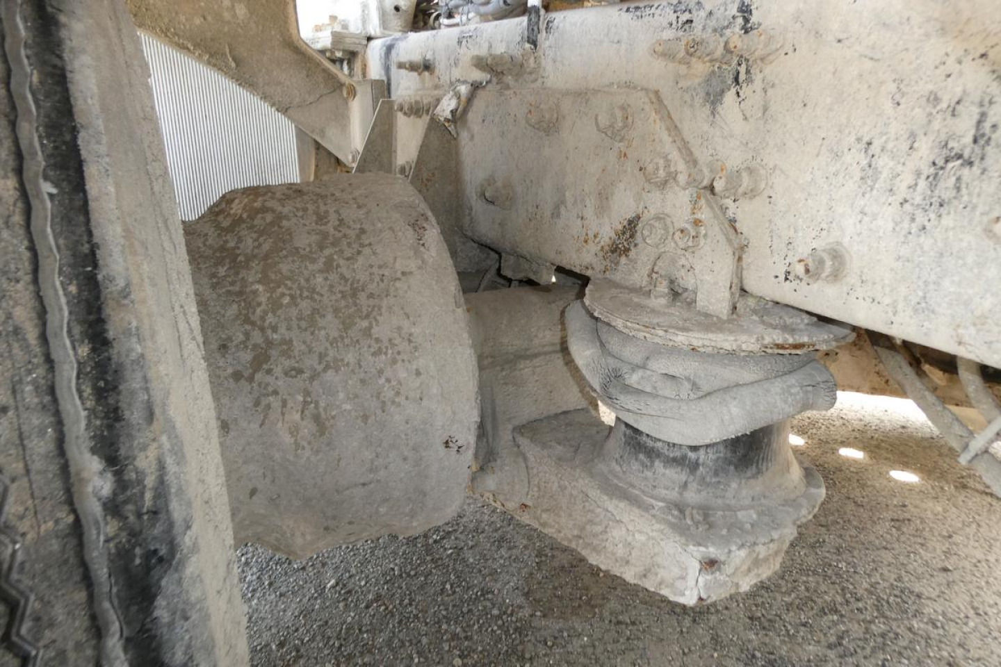 Mack mixer truck undercarriage showing chassis, suspension bushings, and drive axle components.