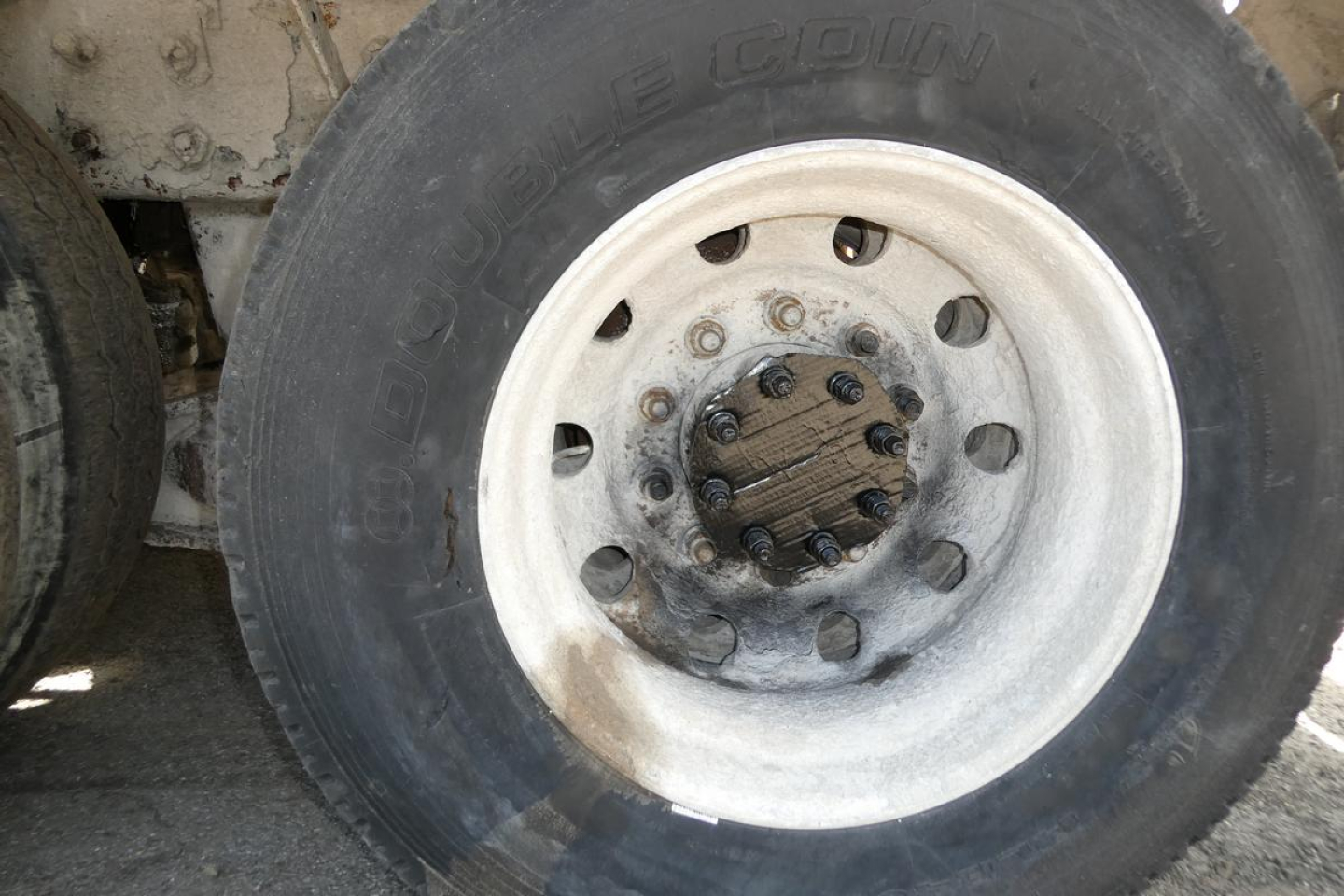 Wheel and tire assembly on a Mack mixer truck showing a metal hub with multiple bolt pattern and a Goodyear tire labeled 'Goodyear' around the rim.