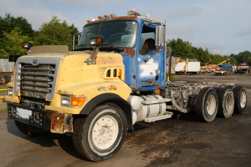 Mack CTP713 mixer truck in-service showing yellow front cab and blue sleeper with multiple wheels and chassis.
