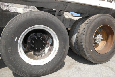 Wheel area of a 2007 Mack CTP713 mixer truck showing front dual wheels with worn tires and rims.