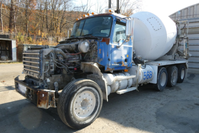 Mack mixer truck with blue cab and white cement mixer drum, front grille exposed engine area, number 568 on door, in-service condition.