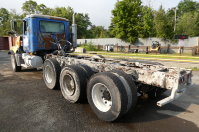 Mack CTP713 mixer truck chassis showing rear wheels and frame with weathered components.