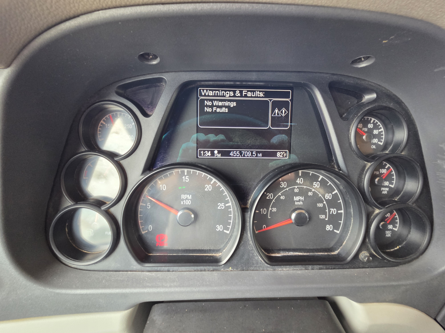 Peterbilt truck gauge cluster showing digital display with warnings: No Warnings No Faults; analog gauges for RPM, speed, fuel, and other indicators.