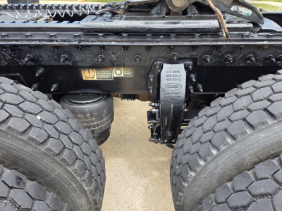 Peterbilt truck chassis undercarriage showing suspension and differential, with visible labels/ stickers on the frame and air lines.
