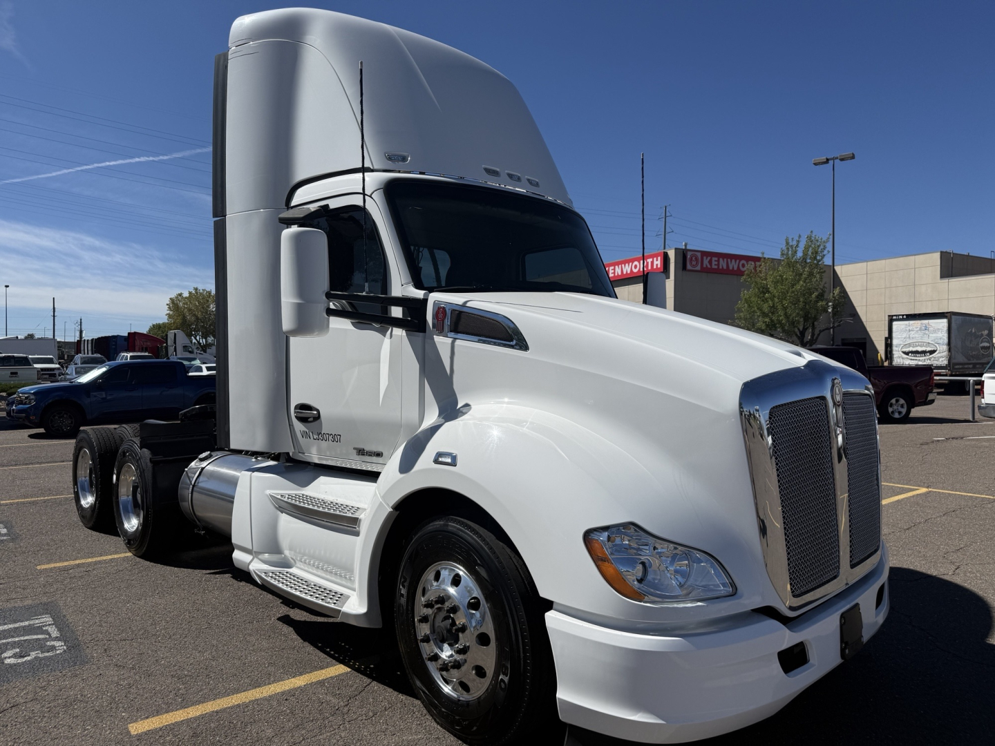Kenworth T680 tractor-trailer cab in white, front-left view, with large aerodynamic sleeper and chrome grille, daycab configuration.