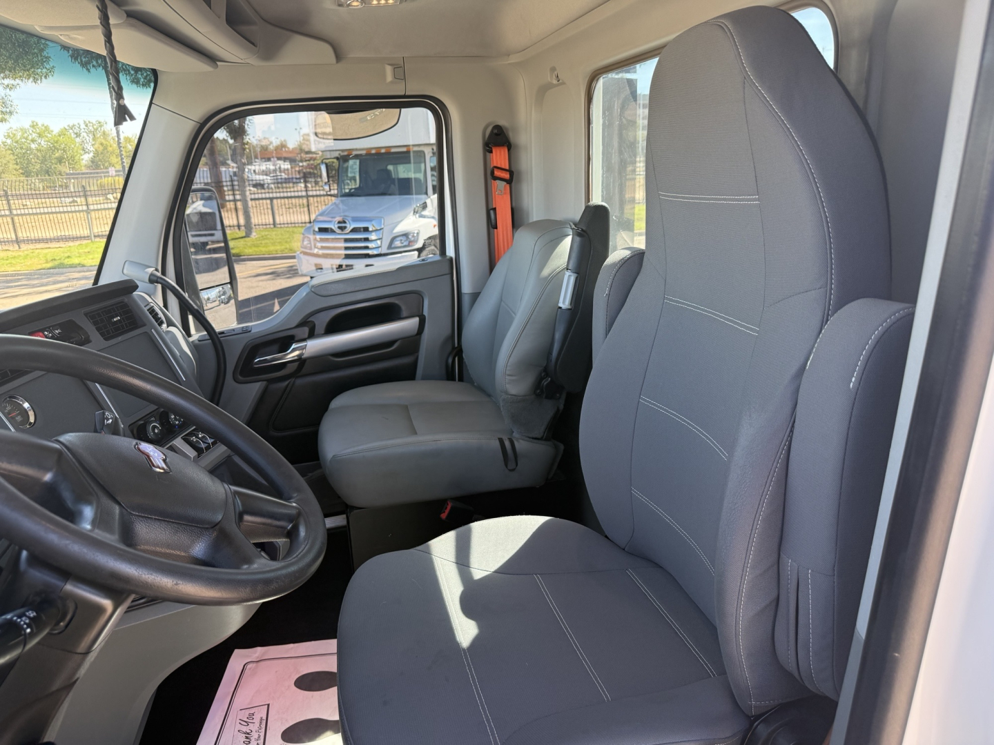 Kenworth T680 interior cabin showing driver and passenger seats and steering wheel in cab.