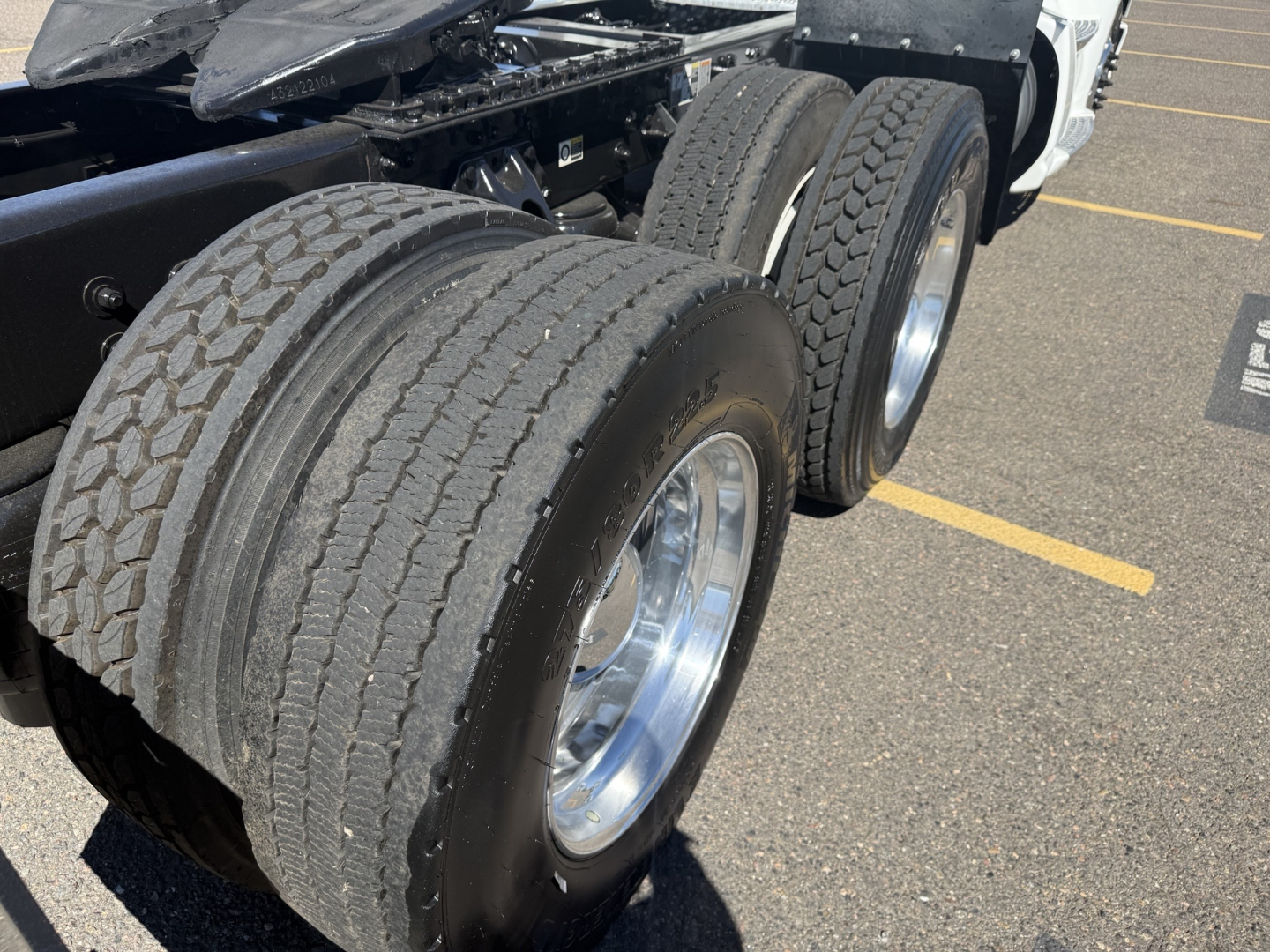 Kenworth T680 truck rear dual tires with chrome wheels and black chassis, part of a Daycab tractor.