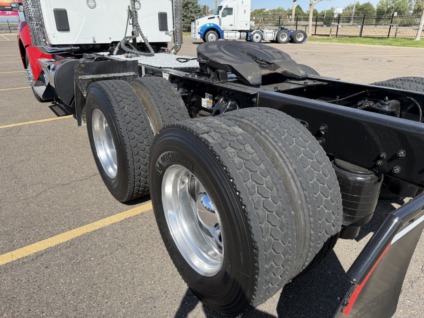 Kenworth T880 truck chassis showing dual rear axles and tires with visible fuel tank and frame.