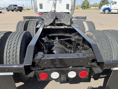 Kenworth T880 chassis showing rear view with dual rear axles and fifth-wheel mounting area, exposed suspension and frame components, taillights visible.